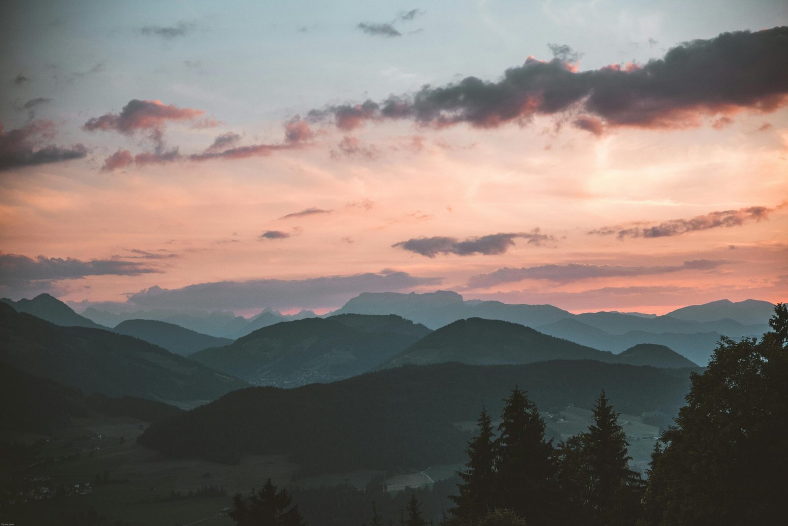 Layered mountains beneath a pink evening sky