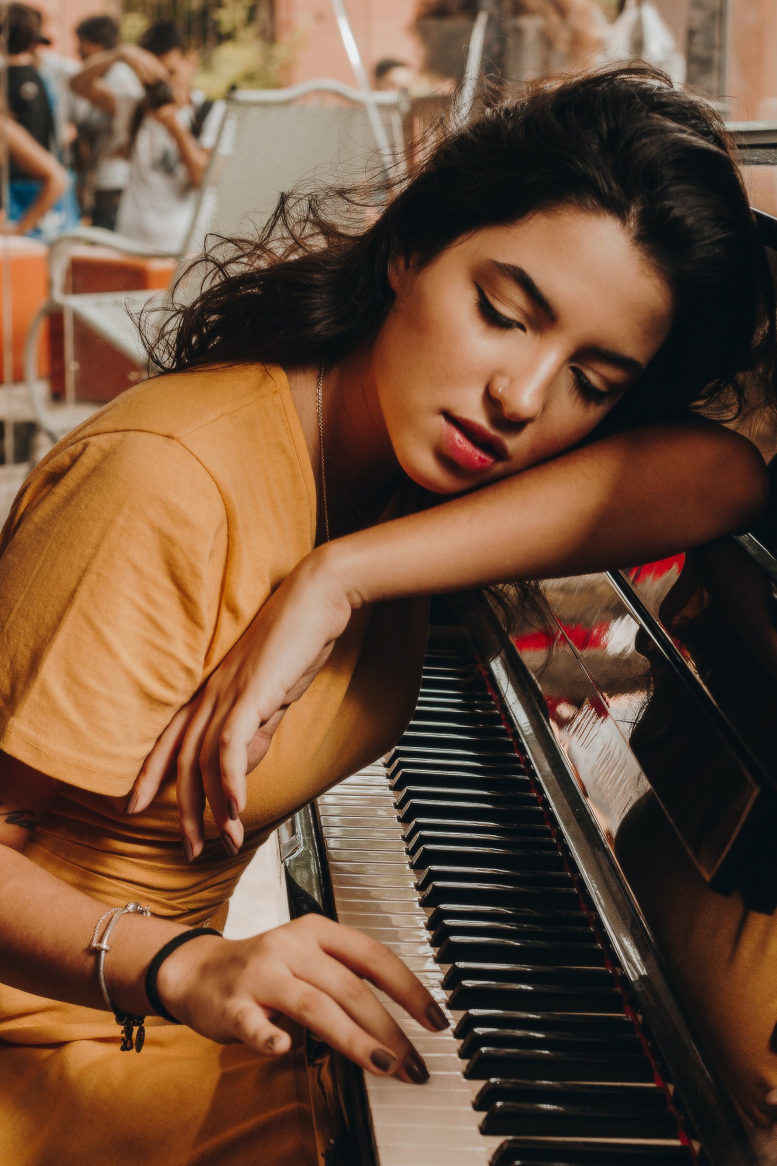 A woman resting her head on a piano